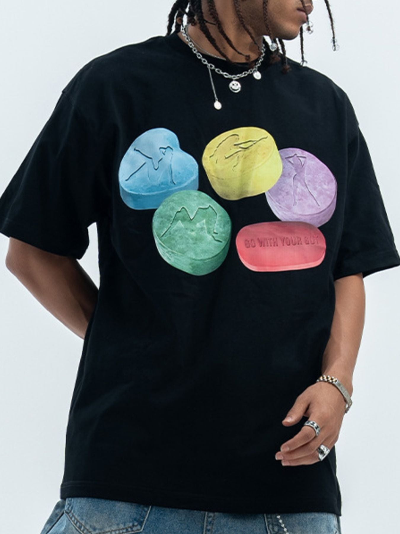 Black cotton crew neck t-shirt with graphic print of colorful pills.
