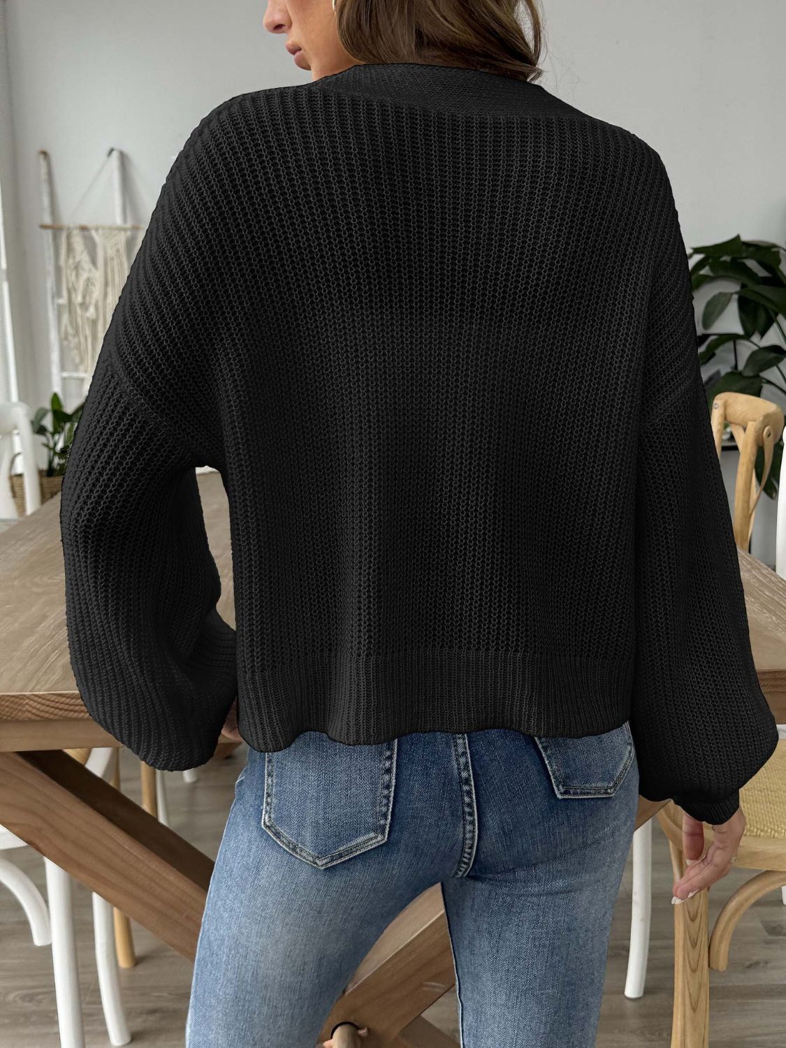 Black balloon sleeve cardigan with textured knit and button front detail.