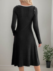 Black ribbed knit dress with long sleeves and a white neckline detail.