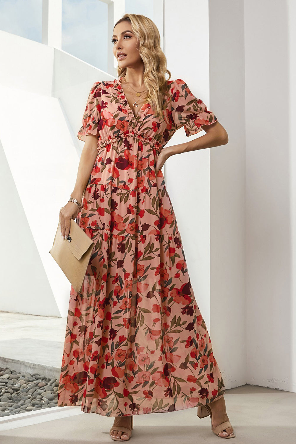 Tiered floral maxi dress with puff sleeves and ruffled V-neck in a peachy pink hue.
