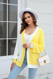 Colorblock knit cardigan with contrast trim in yellow and white acrylic, featuring balloon sleeves and a relaxed fit.