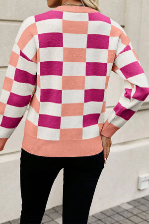 Off-shoulder knit pullover with checkerboard pattern in pink, peach, and white.