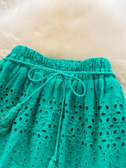 Green eyelet maxi skirt with tiered detail, drawstring waist, and tassels.