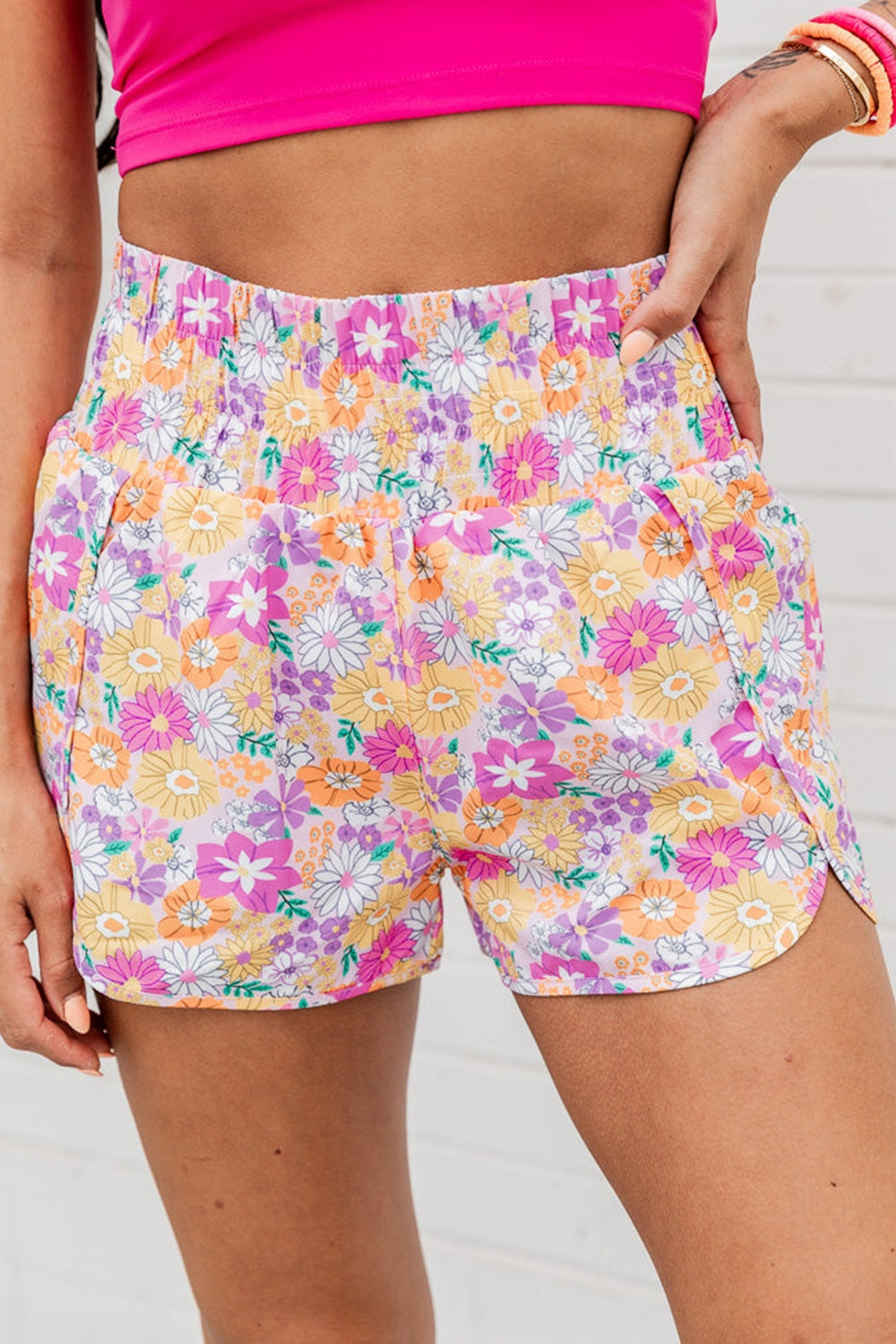 Floral print shorts with scalloped hem and elastic waistband in blush pink with multicolor flowers.