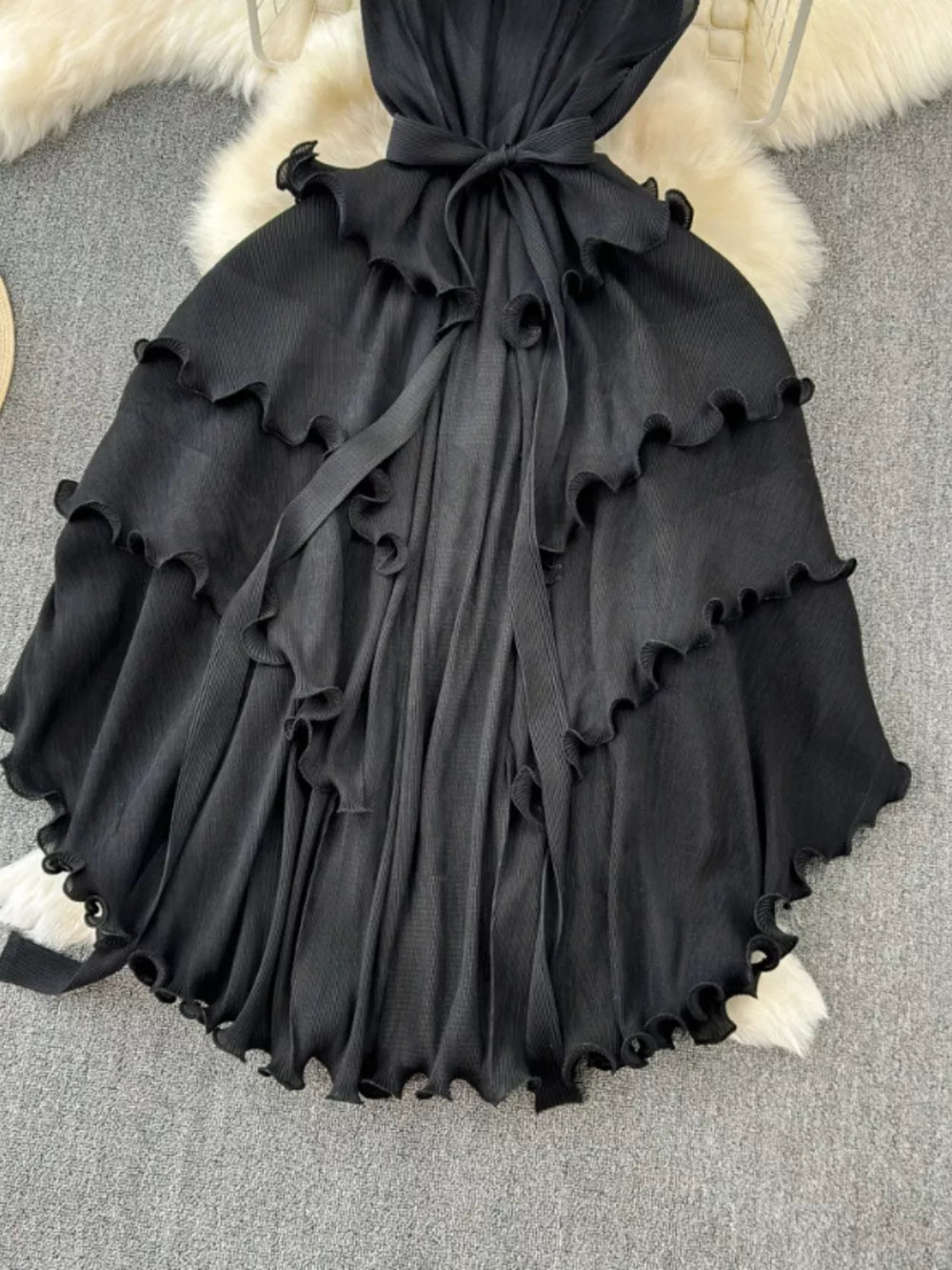 Black ruffled tiered midi dress with belted waist and frill trim.