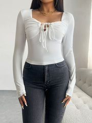 White ruched bustier long sleeve top with tie detail and square neckline.