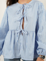 Striped blue and white tie-front peplum blouse with voluminous sleeves and a ruffled hem.