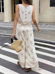 White two-piece set with medallion print, sleeveless top with button back, and wide-leg pants.