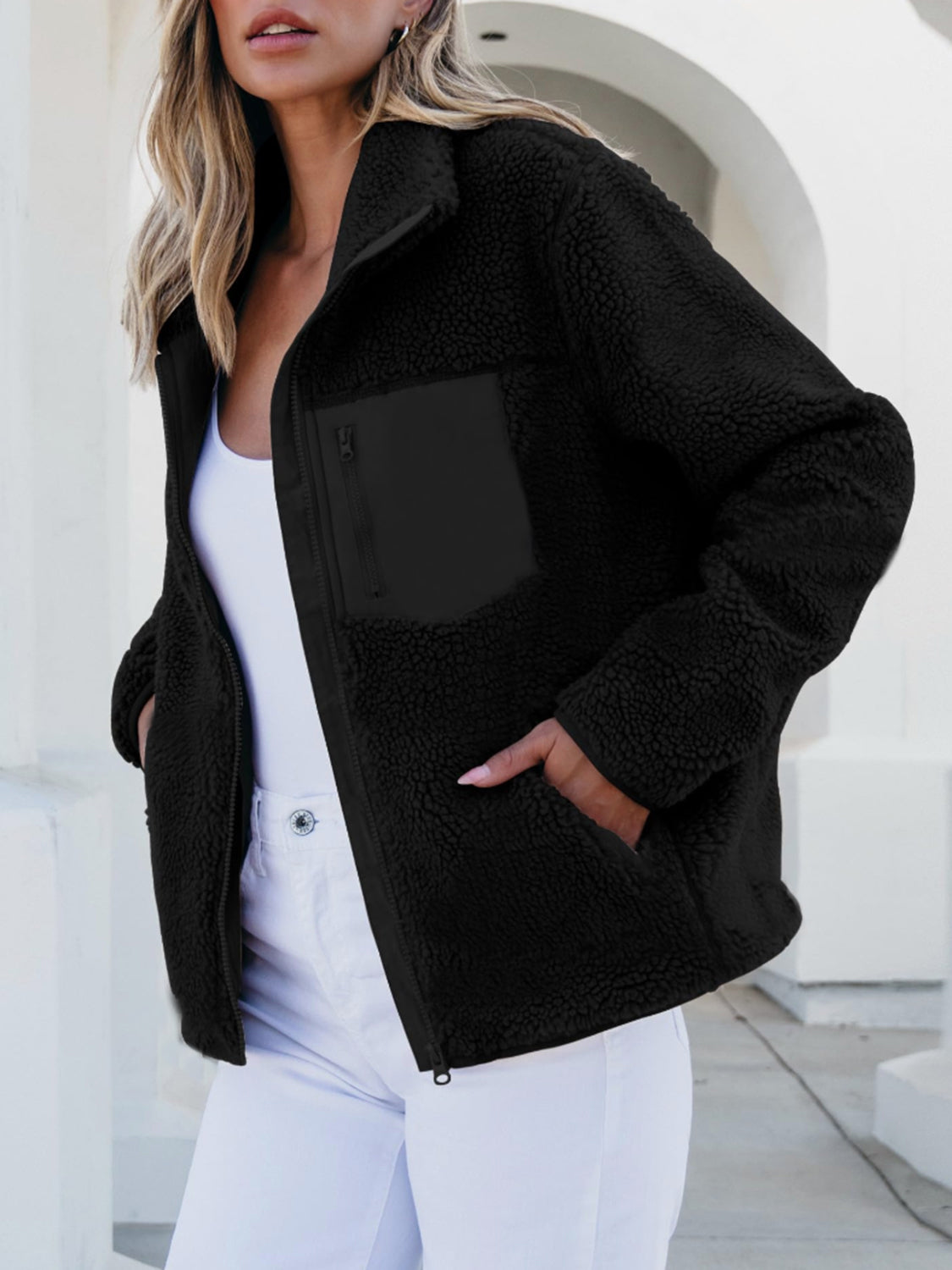 Black sherpa zip-up jacket with zip chest pocket and side pockets.