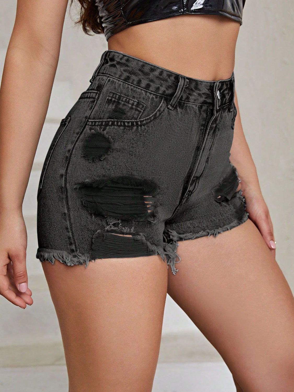 Distressed denim shorts in gray with frayed hem and ripped details.