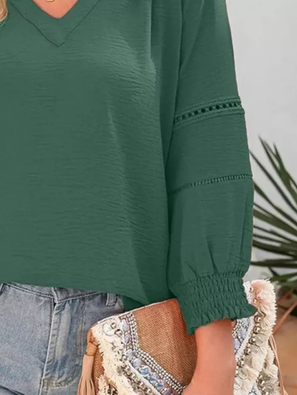Green long sleeve polyester blouse with smocked cuffs and eyelet detail on sleeves.