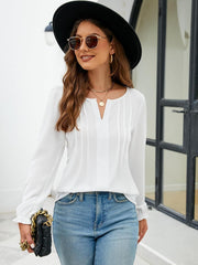 White textured pleat-front blouse with v-neck and ruffle cuffs.