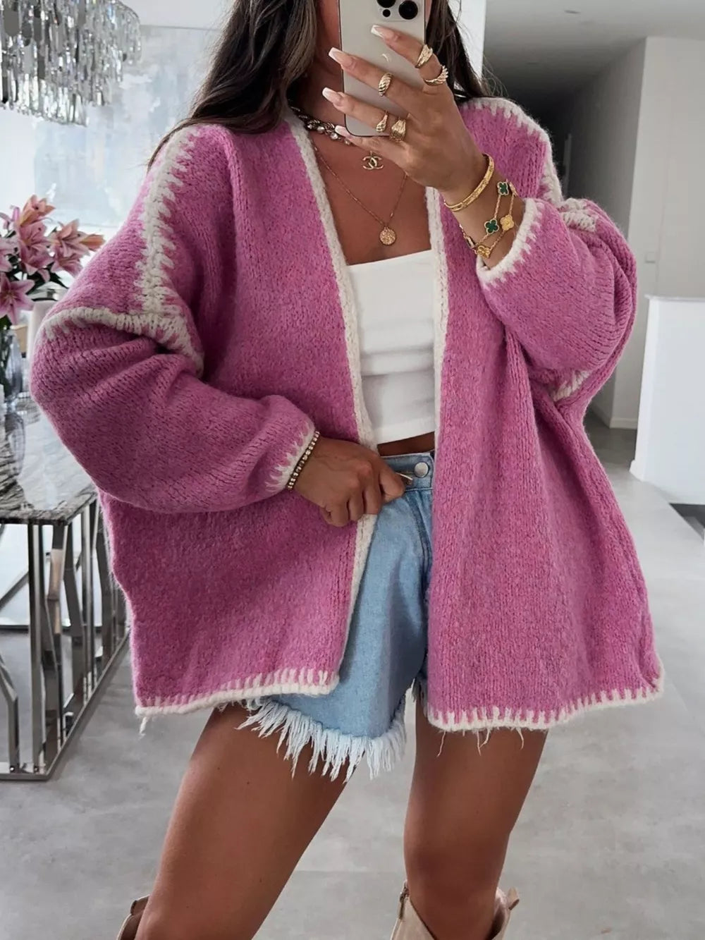 Oversized pink cardigan with contrast trim and white detailing on sleeves and hem.