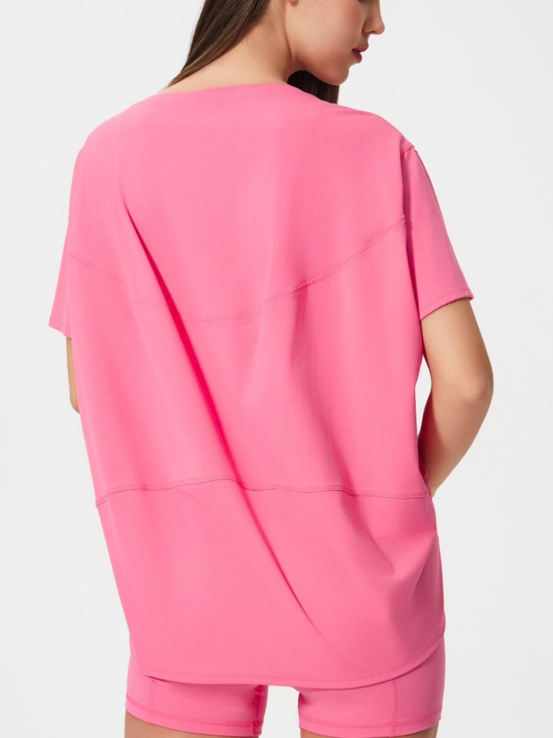 Relaxed fit performance tee in fuchsia pink with short sleeves and seam details.