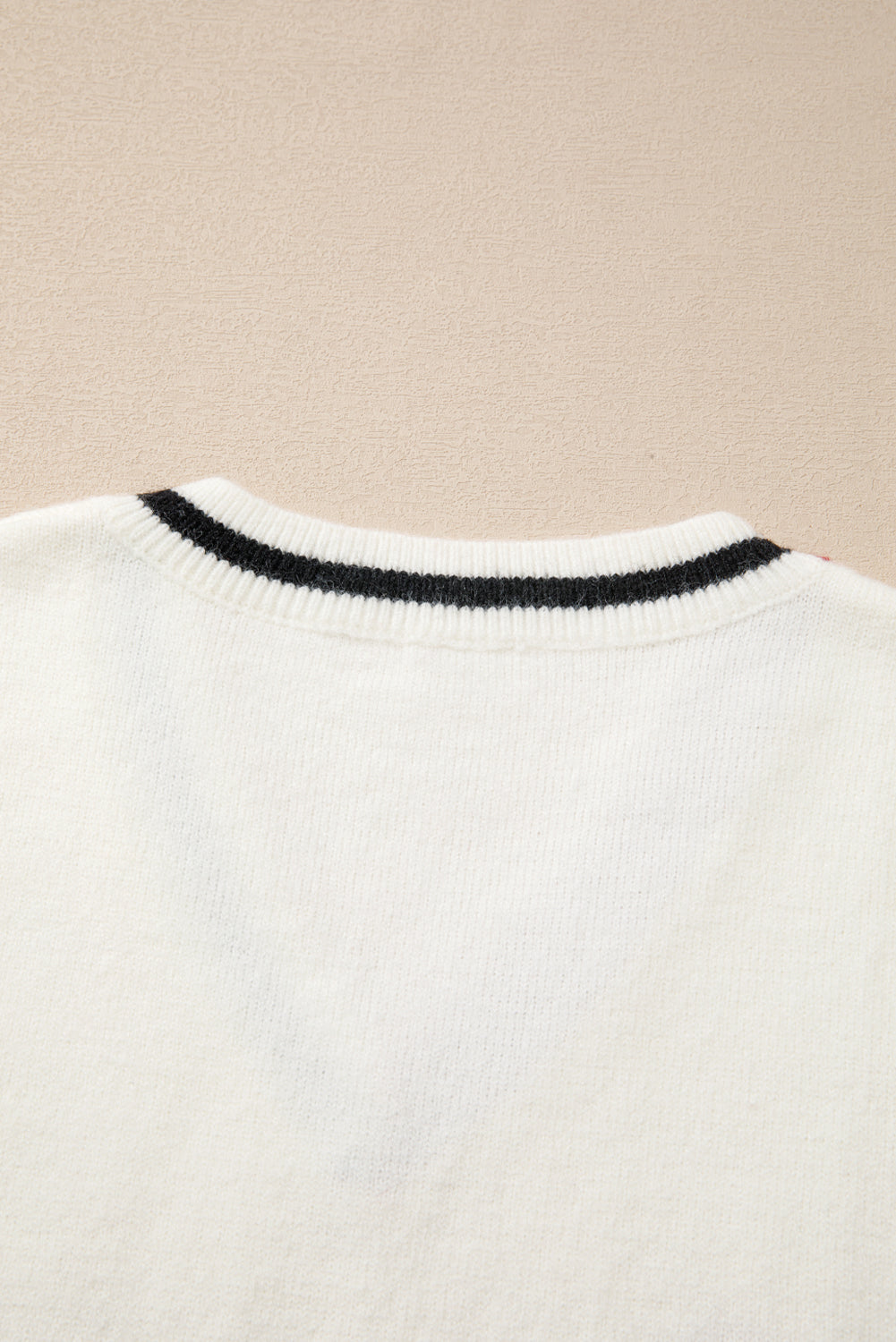 White knit vest with black striped neckline detail