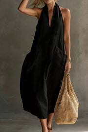 Black halter midi dress with deep V-neck and large front pockets.