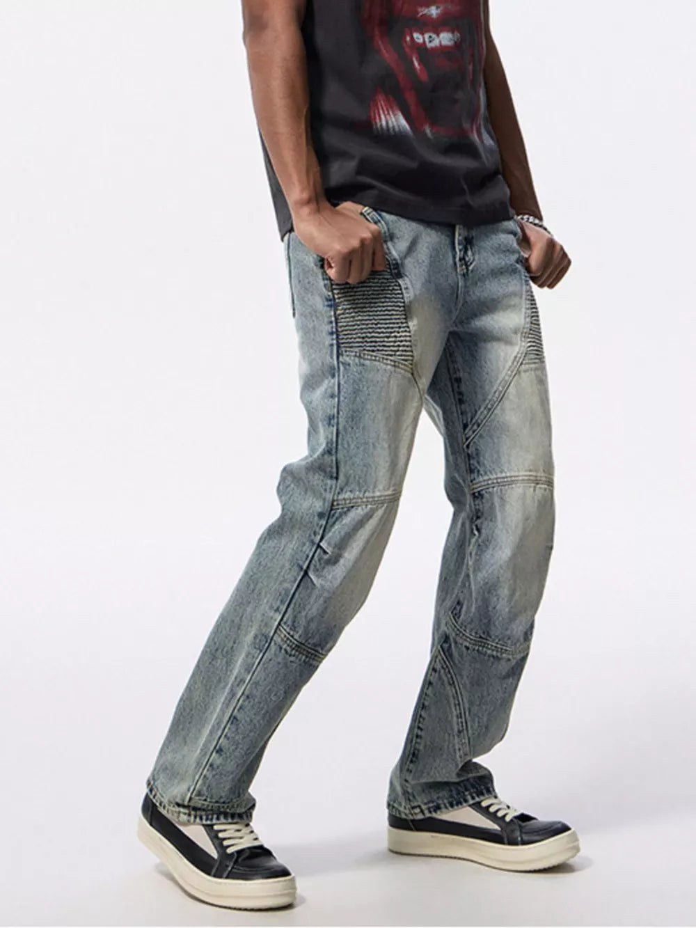 Men's light wash denim moto jeans with ribbed knee panels and wide leg.