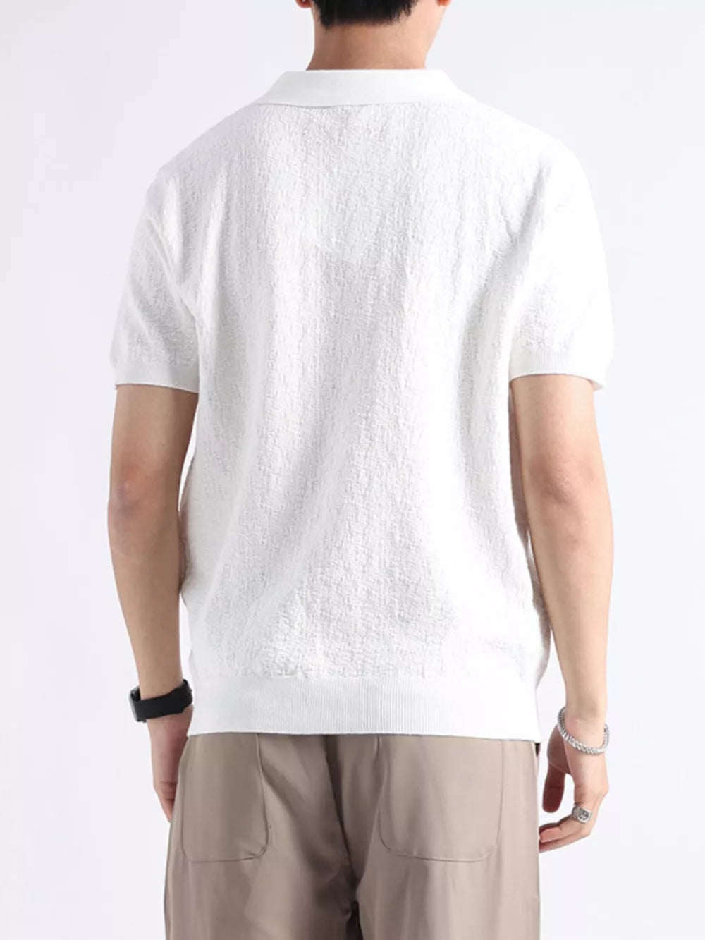 White cotton blend short-sleeve polo with textured fabric and classic collar.
