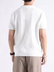 White cotton blend short-sleeve polo with textured fabric and classic collar.
