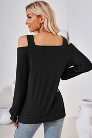 Black geometric cutout shoulder top with long sleeves and a square neckline.
