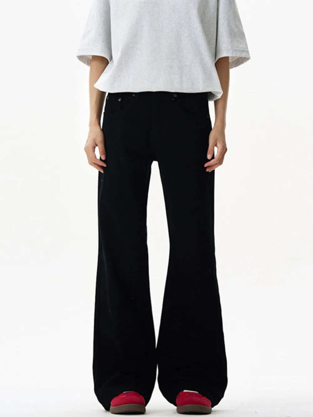 Black wide-leg sweatpants with a relaxed fit and flared hem, styled with a grey t-shirt.