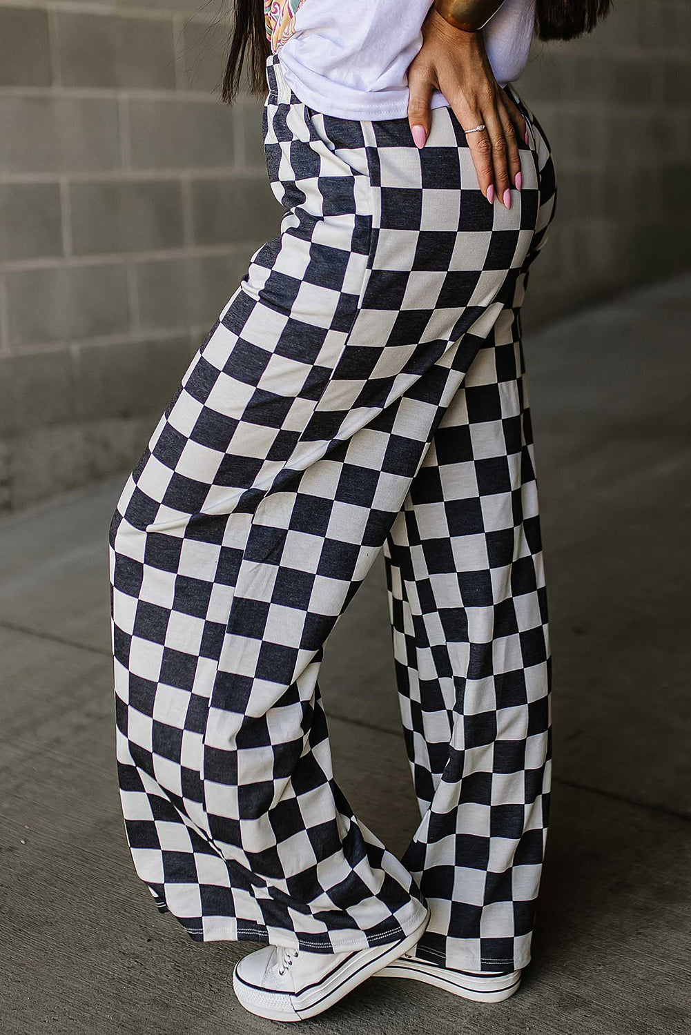 Checkerboard palazzo trousers in black and white, featuring a wide leg and casual styling.