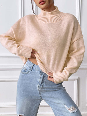 Cropped ribbed turtleneck knit sweater in blush pink with cuffed sleeves and hem.