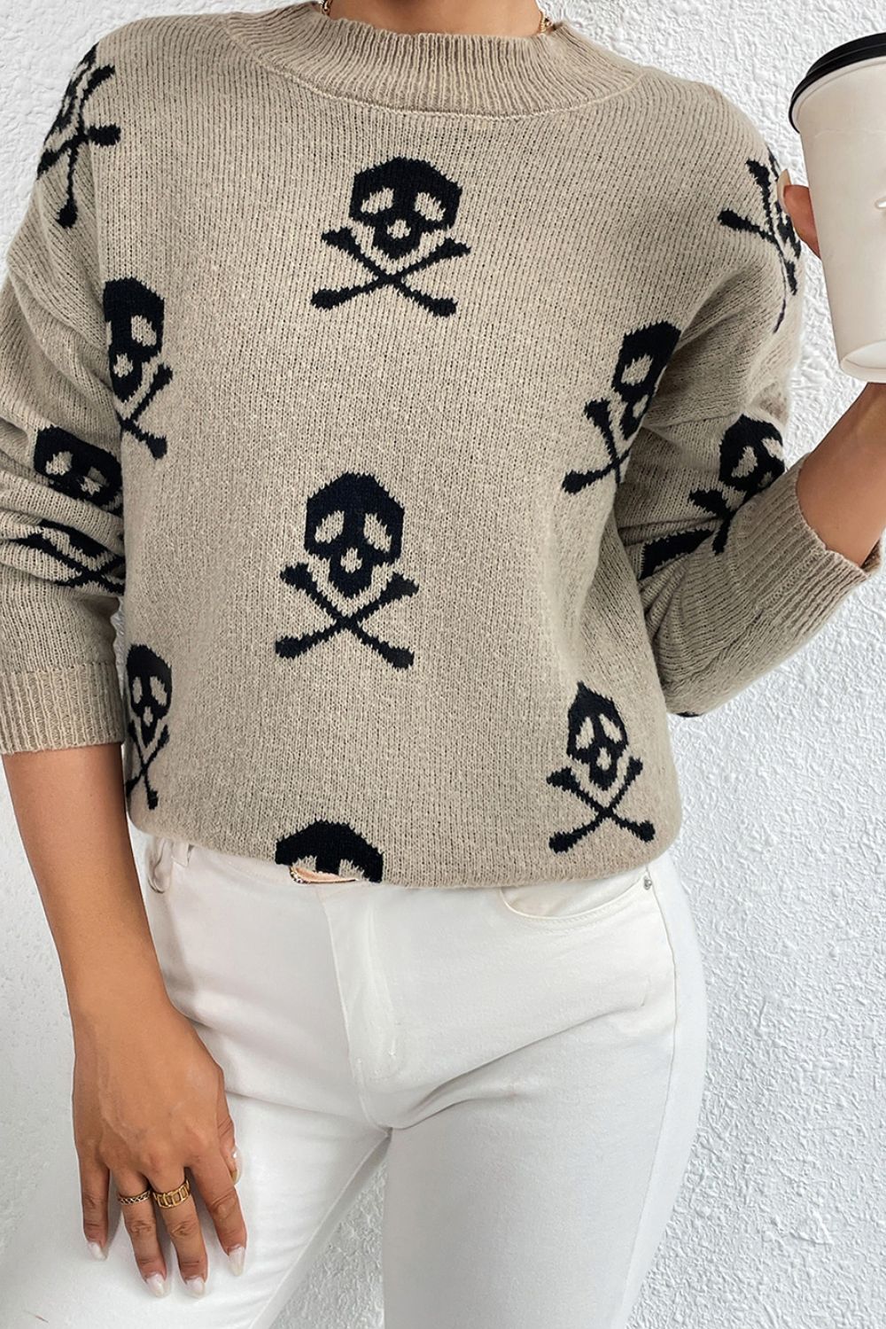 Khaki knit mock neck sweater with allover black skull and crossbones motif.