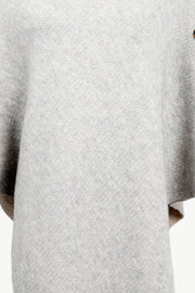 Light gray acrylic knit poncho with button detail and turtleneck