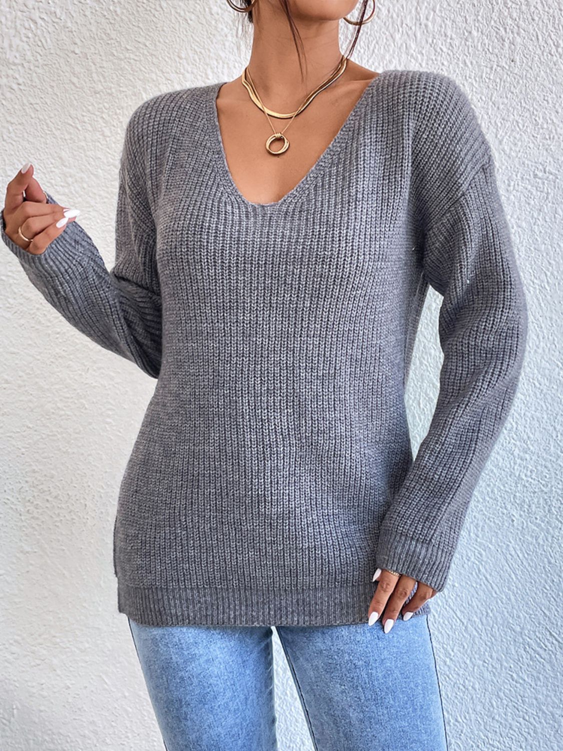 Gray ribbed knit sweater with V-neck and long sleeves, featuring a subtle lace detail on the back.