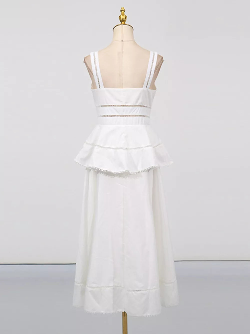 White eyelet embroidered midi dress with tiered ruffle skirt and cutout waist detail.