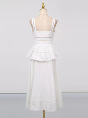 White eyelet embroidered midi dress with tiered ruffle skirt and cutout waist detail.