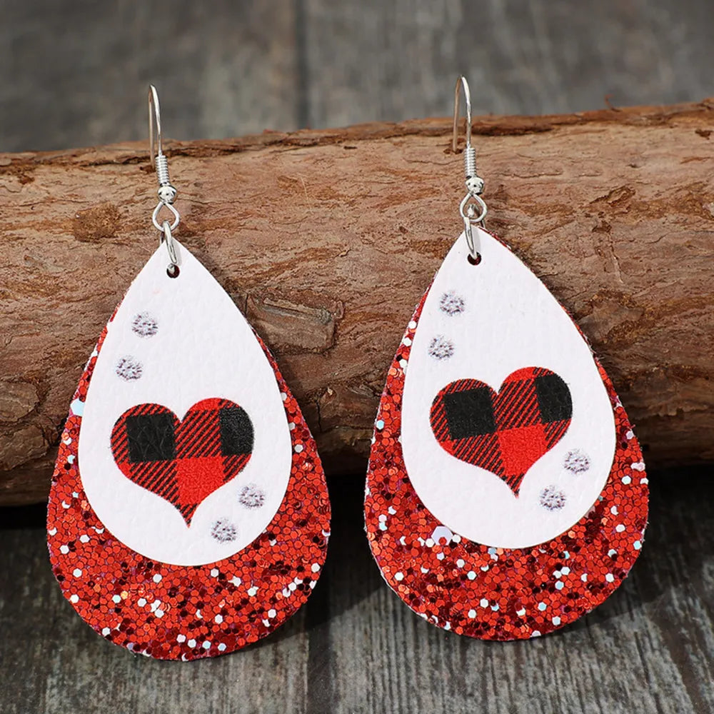 Red plaid heart teardrop earrings with glitter accents.