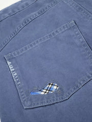 Blue faded cargo capris with distressed detailing and plaid pocket accent.