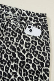 Chic cropped leopard print denim jeans with a white phone in the pocket.