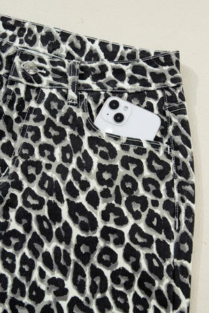 Chic cropped leopard print denim jeans with a white phone in the pocket.