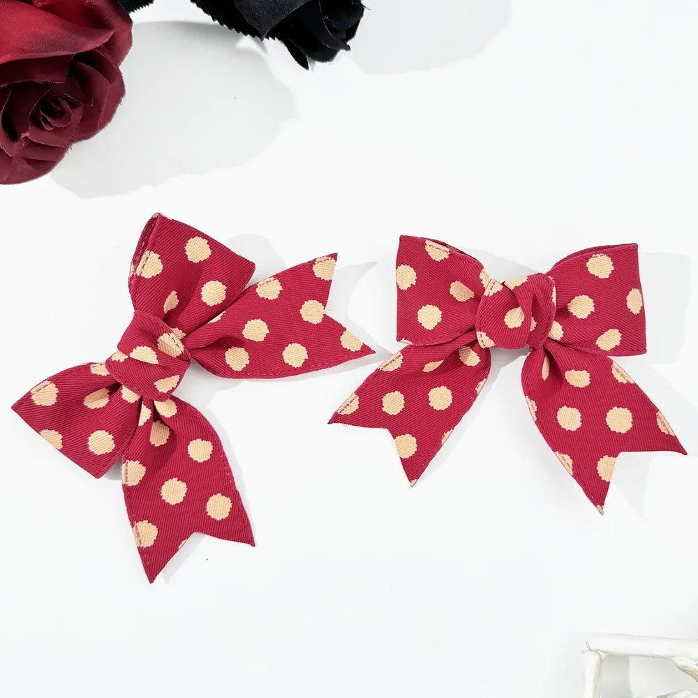 Deep red polka dot bow barrettes, a 2-piece set for adults.