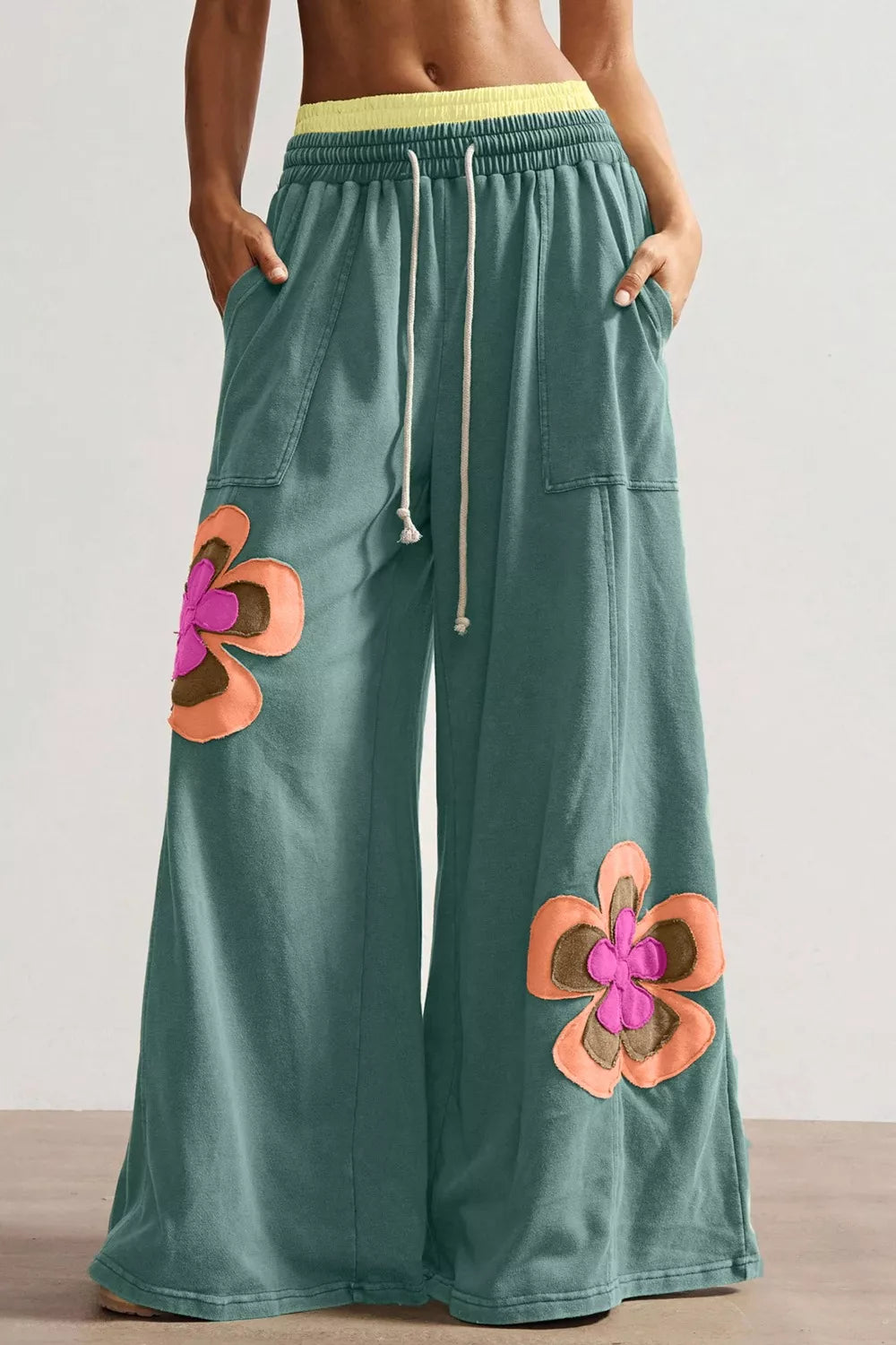Green cotton sweatpants with floral appliques and drawstring waist
