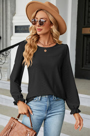Black textured puff sleeve blouse with ruffled cuffs and crew neck.