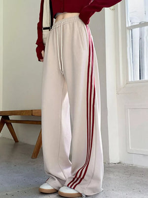 Effortless striped wide-leg maternity joggers in apricot with red side stripes and drawstring.