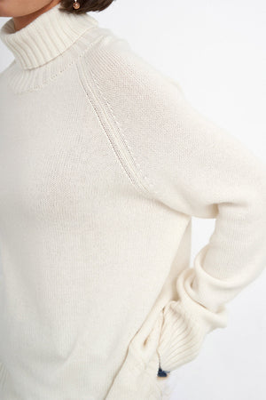 Sand cashmere turtleneck sweater with raglan sleeves and ribbed cuffs.