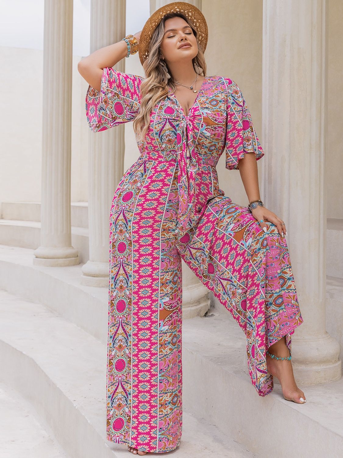 Bohemian tie-front palazzo jumpsuit in Deep Rose with bell sleeves and vibrant paisley print.