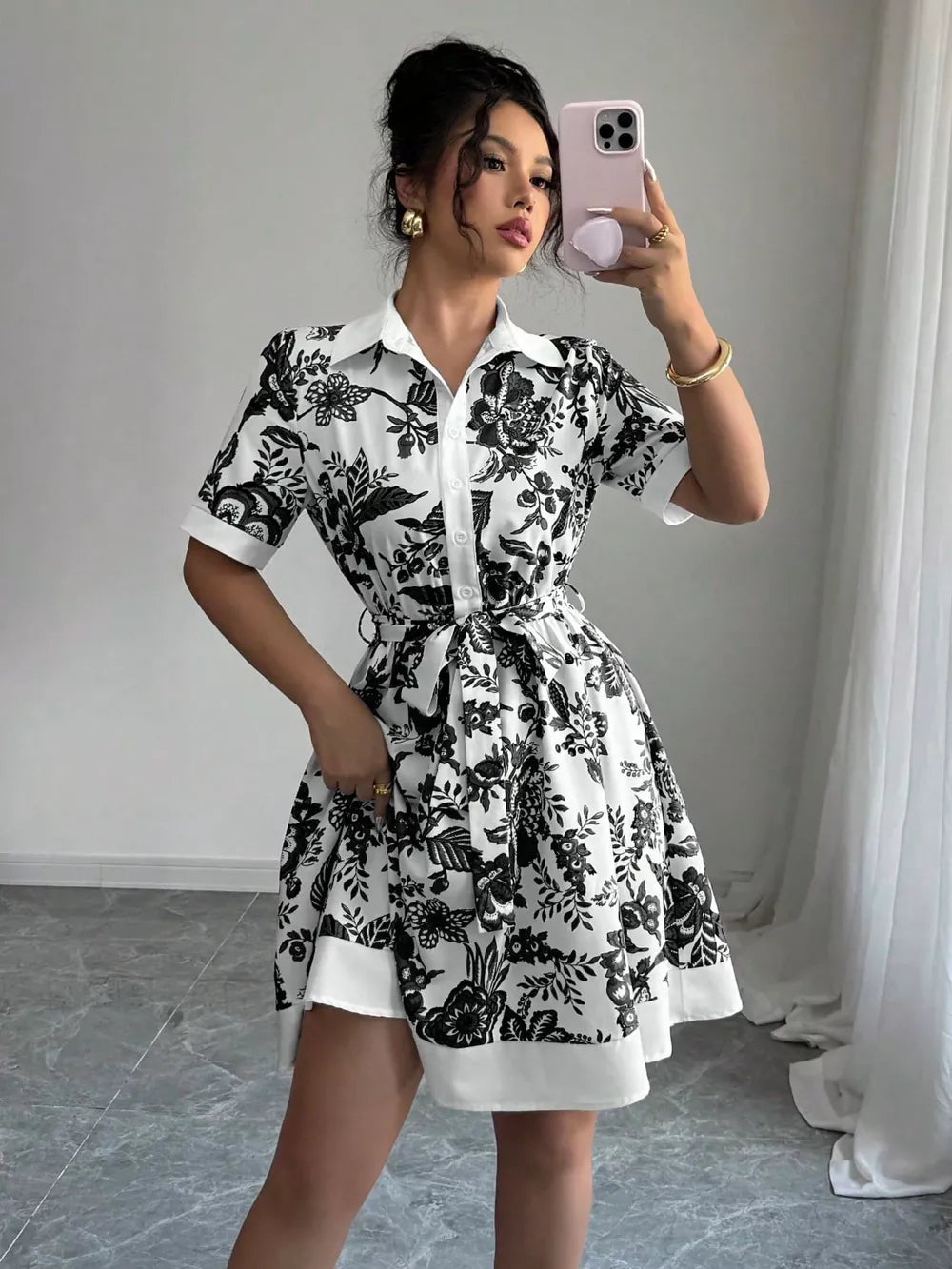 Floral print mini dress with tie belt, short sleeves, and collared neckline.