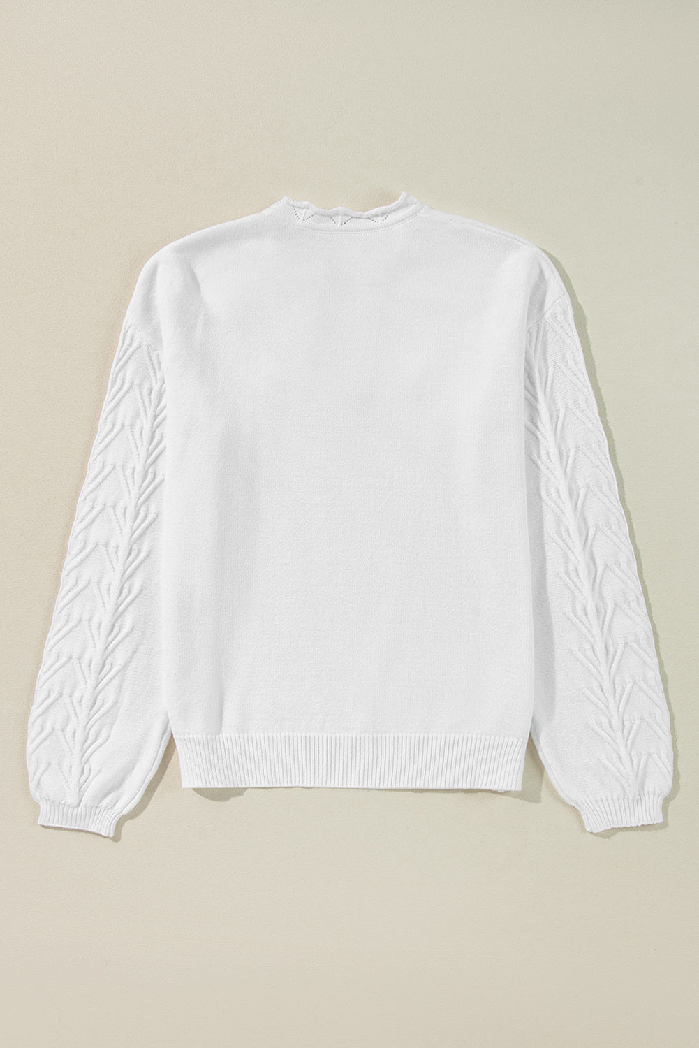 White knit sweater with textured leaf pattern on sleeves and scalloped notch neck.