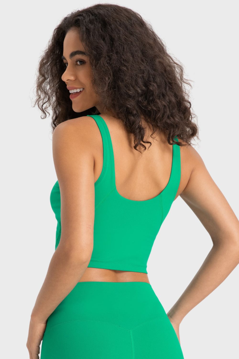Green scoop neck crop top with thick straps and a cropped hem.
