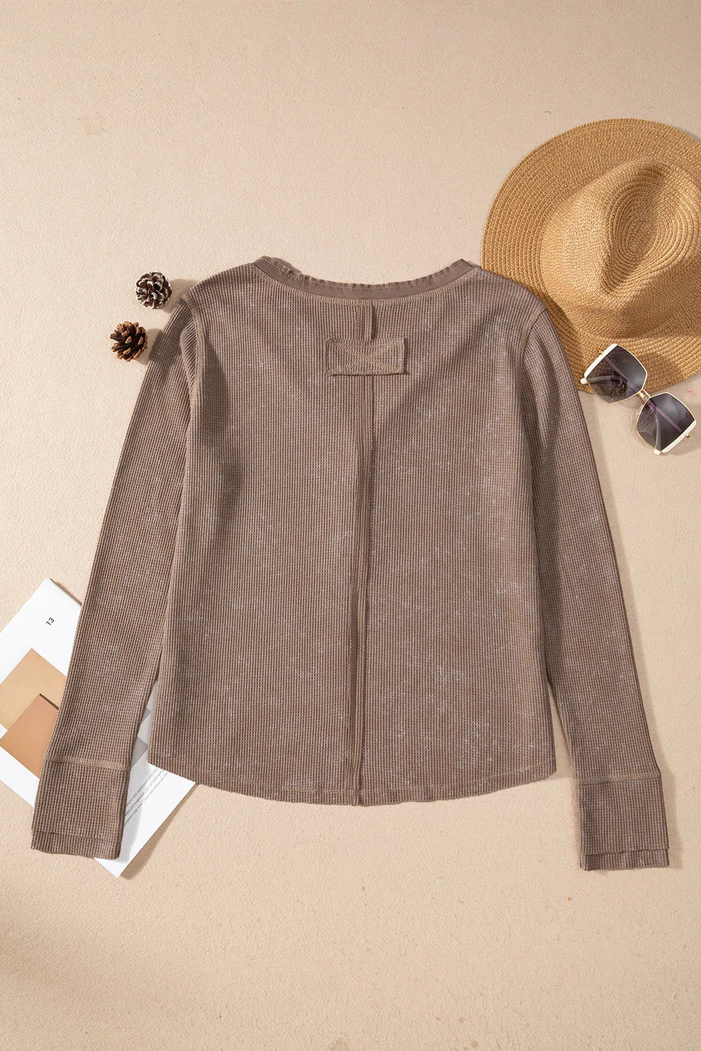 Taupe waffle knit long sleeve blouse with a notch neckline and button detail.