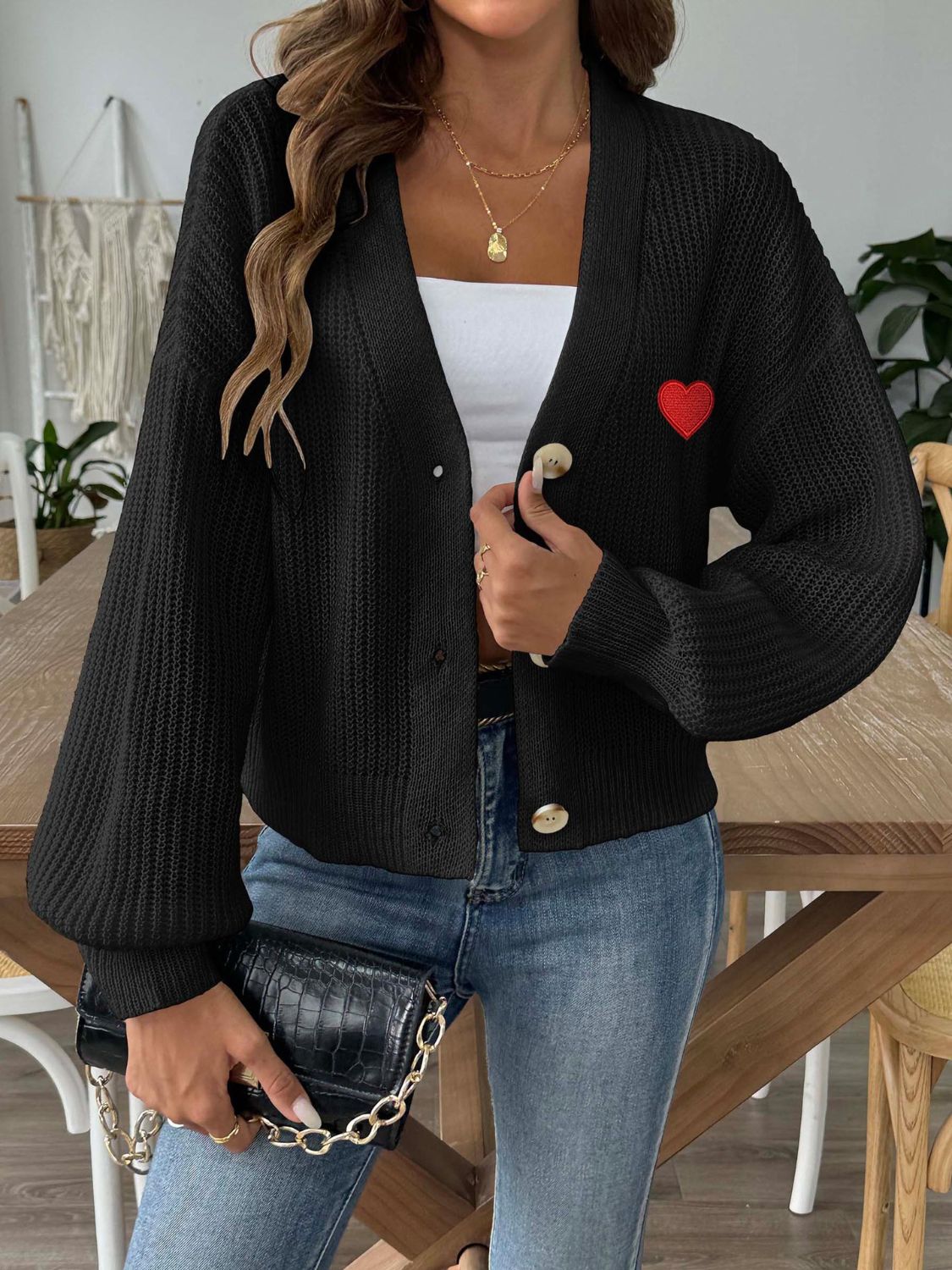Black balloon sleeve cardigan with red heart appliqué and button front.