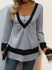 Gray long sleeve top with contrast black V-neck trim, gathered yoke, and hem band.