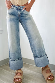Medium washed denim jeans with wide cuffed hems.