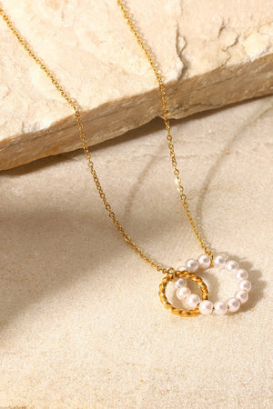 Gold-plated necklace with interlocking pearl and twisted circle pendants.